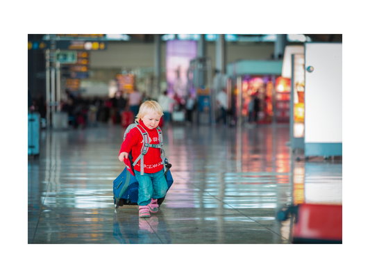 toddler walking through an airport with suitcase - Smiley Tot