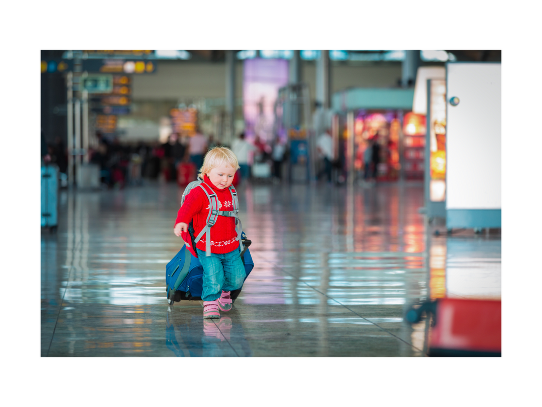 toddler walking through an airport with suitcase - Smiley Tot 